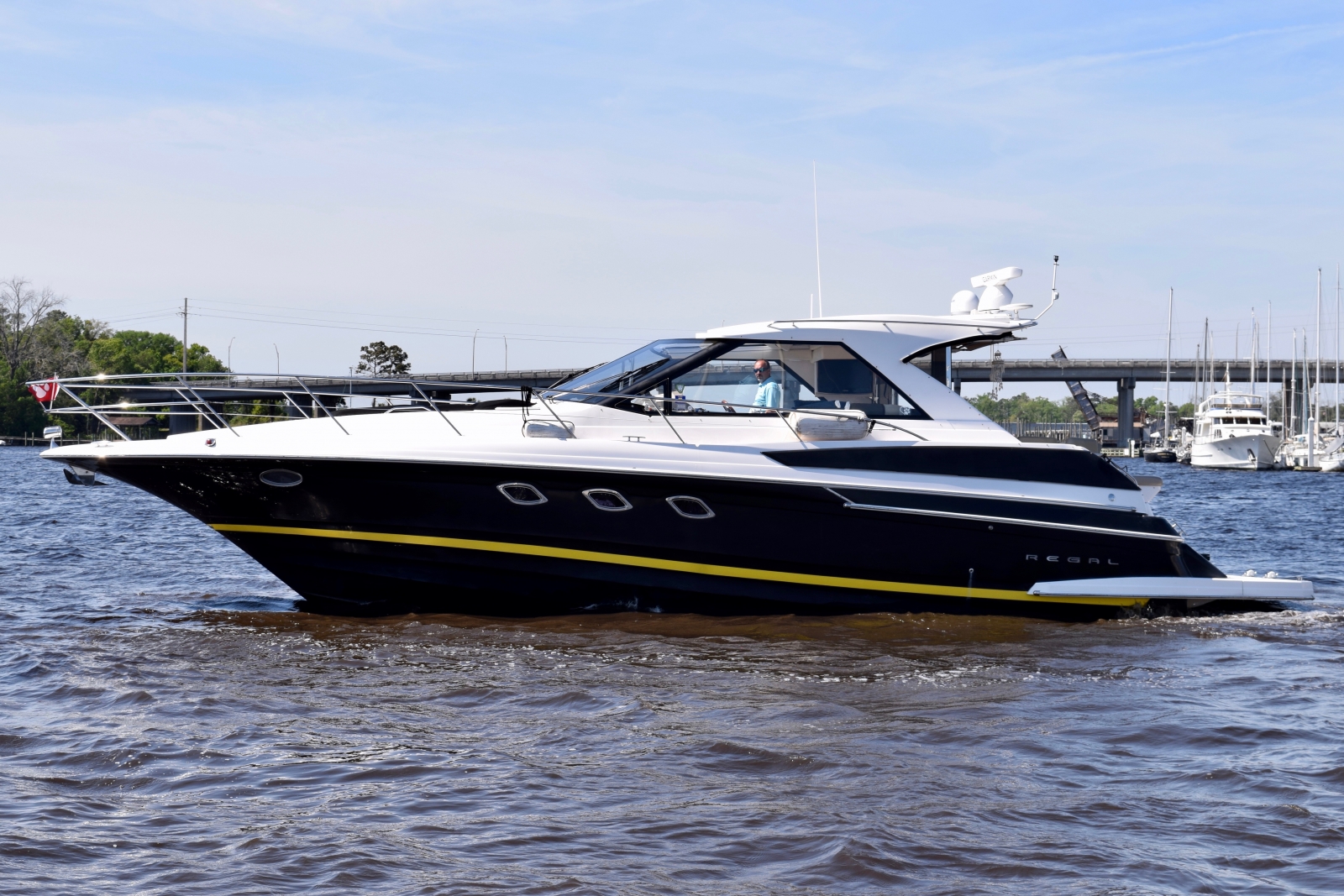 2010 Regal 44 Sport Coupe with yellow boot stripe on the water at marina.