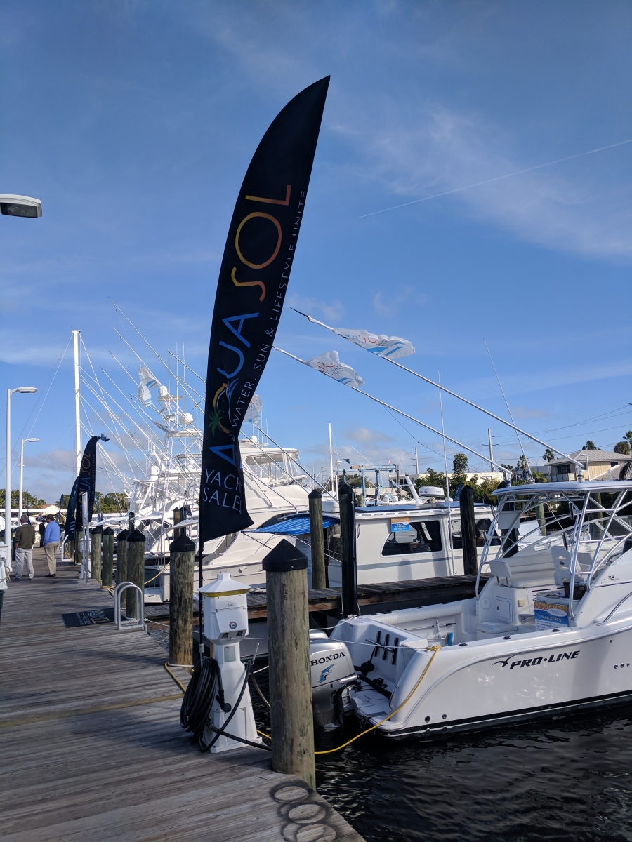 Boats at boat show with Aqua Sol Yacht Sales flag